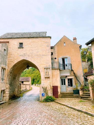 an archway in an old stone building with a street at Maison des Gardes in Noyers-sur-Serein in Noyers-sur-Serein