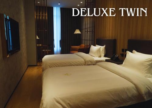 two beds in a hotel room with the words deliver twin at LOTUS BLU HOTEL Naga 