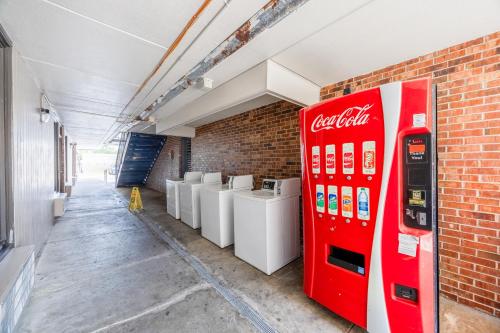 a coca cola vending machine next to a brick wall at Oyo Hotel Bartow in Bartow