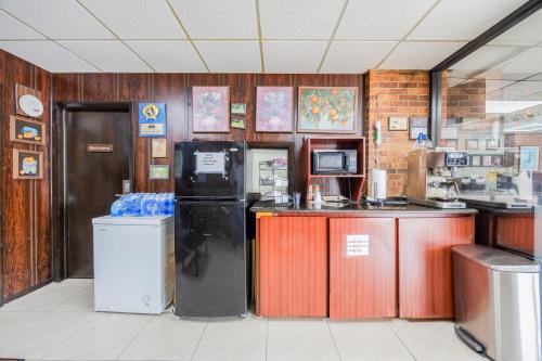 a kitchen with a counter with a refrigerator and a counter at Oyo Hotel Bartow in Bartow