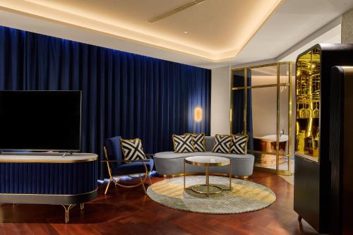 a living room with blue curtains and a couch and a table at OKU Hotel in Taichung