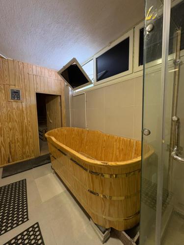 a wooden tub in a bathroom with a shower at Coronado Dabaa Beach in Zāwiyat ‘Abd al Mun‘im