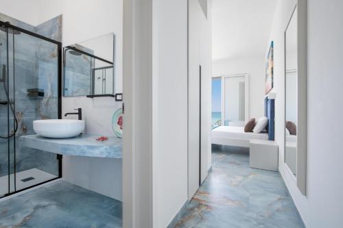 a bathroom with a sink and a mirror at Nella Suites Rooms in Torre Lapillo