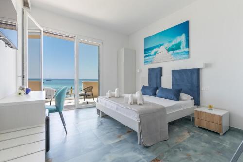 a bedroom with a bed and a view of the ocean at Nella Suites Rooms in Torre Lapillo