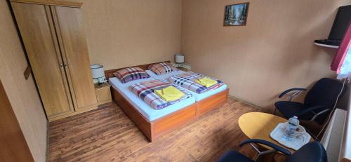 a bedroom with a bed in a room with chairs at Gospodarstwo Agroturystyczne Agroletnica in Świdnica