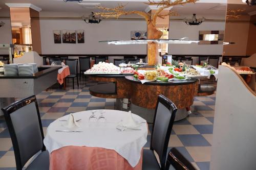 a dining room with tables with plates of food at Santa Monica Playa in Salou