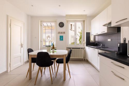 une cuisine avec une table et des chaises dans une pièce dans l'établissement Appartement de Prestige au centre climatisé avec jardin privé, à Colmar