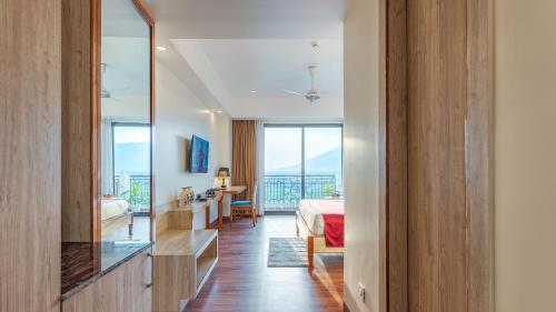 a bedroom with a bed and a desk and a mirror at Mystique Mayong Resort in Rāja Māyang