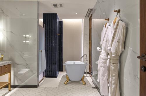 a bathroom with a tub and a toilet and a shower at OKU Hotel in Taichung