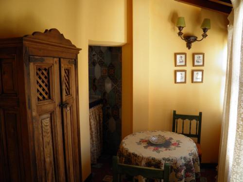 uma sala de jantar com uma mesa e um armário num quarto em Apartamentos La Columna em Chinchón