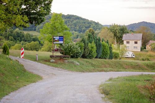 a dirt road with a sign next to a house at Kozline Kordun in Veljun