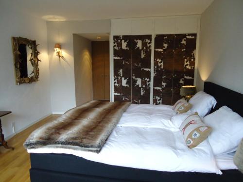 a bedroom with a large bed with a blanket on it at Apartment Humagne - Crans-Montana Center in Crans-Montana