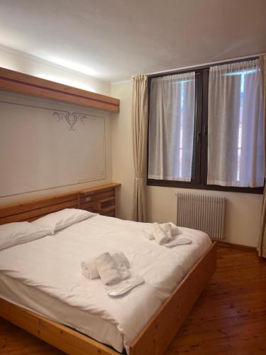 a bedroom with a bed with two towels on it at Hotel De la Ville in Andalo