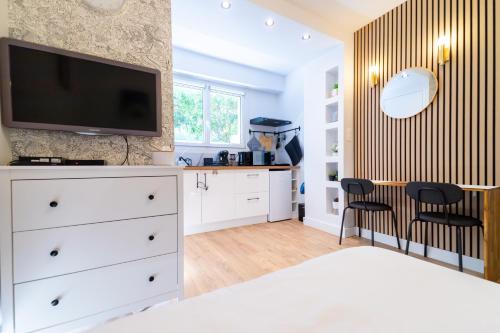ein Schlafzimmer mit einer weißen Kommode und einem TV darauf in der Unterkunft l'Atypique Calme, Proche Gare & Centre ville in Versailles