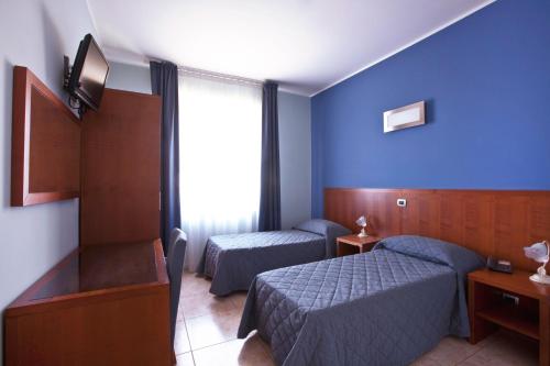 a hotel room with two beds and a window at Hotel San Martino in Cassibile