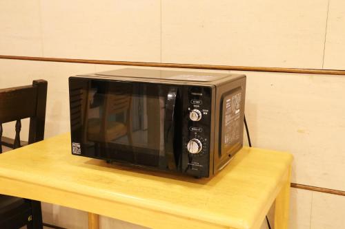 a microwave sitting on top of a wooden table at Country Hotel Takayama in Takayama
