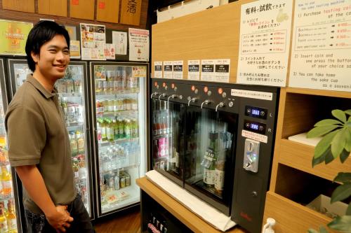 a man standing in front of a cooler in a store at Country Hotel Takayama in Takayama