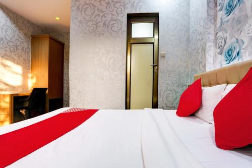 a bedroom with a white bed with red pillows at Hotel O Yatri Yadgar in Mumbai