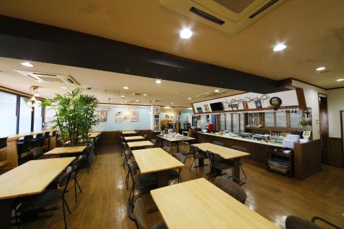 a restaurant with wooden tables and chairs and a bar at Country Hotel Takayama in Takayama