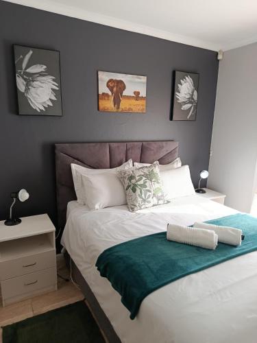 a bedroom with a bed with a green blanket on it at Cleo's Corner in East London