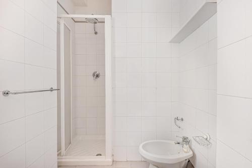 a white bathroom with a shower and a sink at GOLDEN LUXE - Seafront Terrace next to the Beach in Marina di Pietrasanta