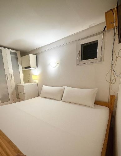 a white bed in a room with a window at Casa di Marghy in Rio Marina