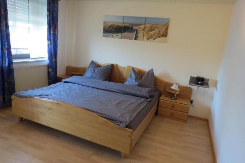a bedroom with a bed with blue sheets and a window at Uller`s Ferienwohnung im Usseltal in Daiting