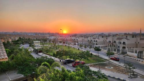 a sunset in a city with cars parked on a street at فيلا فندقية بالشيخ زايد - Zayed Suites B in Sheikh Zayed
