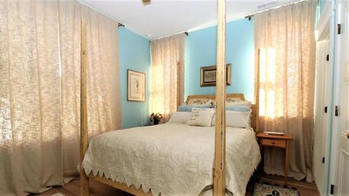 a bedroom with blue walls and a bed with a canopy at 12 Pearls in Cape May Point