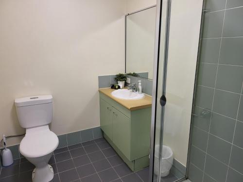 a bathroom with a toilet and a sink and a shower at Noosa Holiday Accommodation in Noosaville