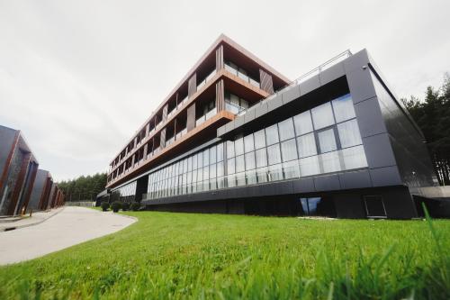 a building with a grass field in front of it at Kass Diamond Resort in Tsalka