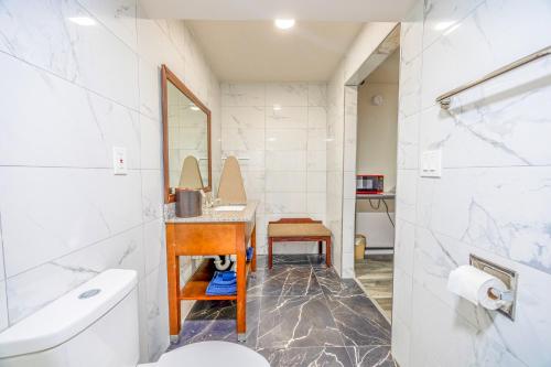 a bathroom with a toilet and a sink and a mirror at Oyo Hotel Bartow in Bartow