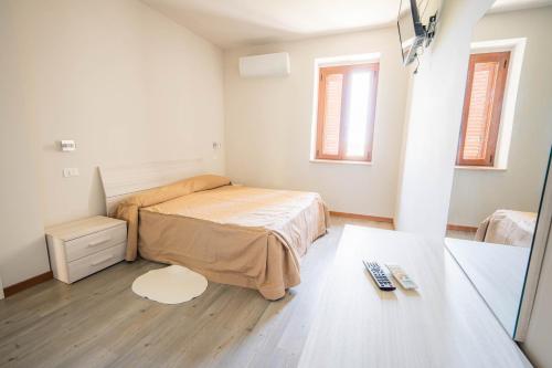 a small bedroom with a bed and a table at Halanus Agriexperience in Alanno