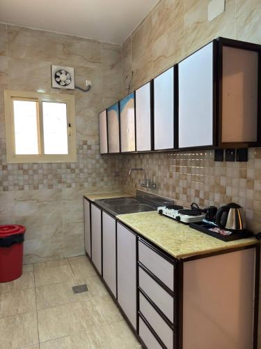 a kitchen with a stove and a counter top at سحاب الأندلس للشقق المخدومة 1 الوجه Sahab Al Andalus for Served Apartments in Al Wajh