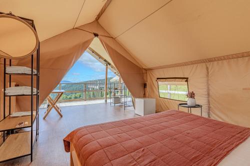 Camera da letto in tenda con letto e balcone. di Bukovel Glamping a Bukovel