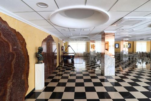 a lobby with a checkered floor and a piano at Santa Monica Playa in Salou