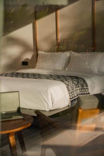 a bedroom with a bed and a laptop on a table at The Placo Villa Uluwatu in Denpasar