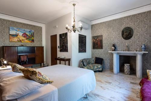 a bedroom with a large bed and a chandelier at I Giardini di Palazzo Ducale deluxe in Pietramelara
