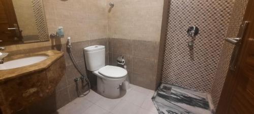 a bathroom with a toilet and a sink and a shower at فندق رواد الهداية in Al ‘Azīzīyah
