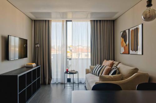 a living room with a couch and a large window at Timbre Boavista in Porto