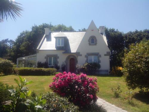 a white house with pink flowers in front of it at Chez Coco in Trégunc