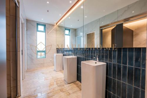 a bathroom with three urinals on the wall at Bay Suites Premier Suites Kota Kinabalu in Kota Kinabalu