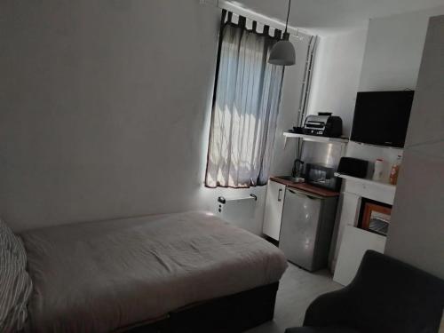 a small room with a bed and a small kitchen at East Suite in London
