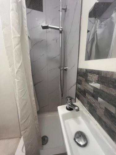 a white bathroom with a shower and a sink at East Suite in London