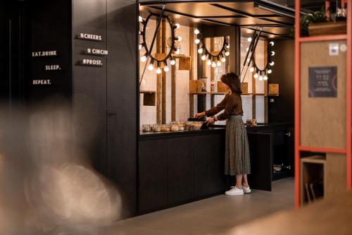 テルメーノにあるHotel Traminerhofの台所の窓口に立つ女