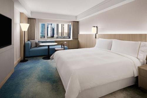 a hotel room with a large white bed and a window at The Westin Josun Busan in Busan