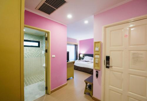 a room with a bed and a shower and a door at La Seine City Resort, Chiang Mai in Chiang Mai