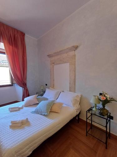 a bedroom with a large bed with a red curtain at Palazzo Cappa-Affitti Brevi Italia in LʼAquila
