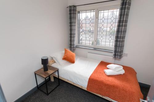 - une chambre avec un lit et une fenêtre avec des serviettes dans l'établissement 4 Bedroom cosy home Birmingham, à Birmingham