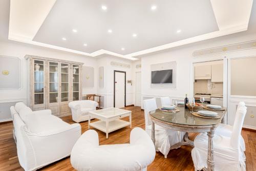 a living room with a table and white chairs at GOLDEN LUXE - Seafront Terrace next to the Beach in Marina di Pietrasanta